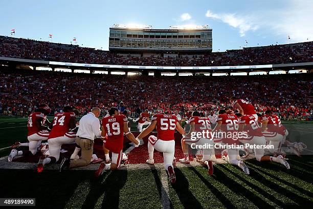 Chikwe Obasih, Leo Musso#19, Garret Dooley, Joe Ferguson, Derek Straus and Austin Ramesh of the Wisconsin Badgers huddle up with teammates at...