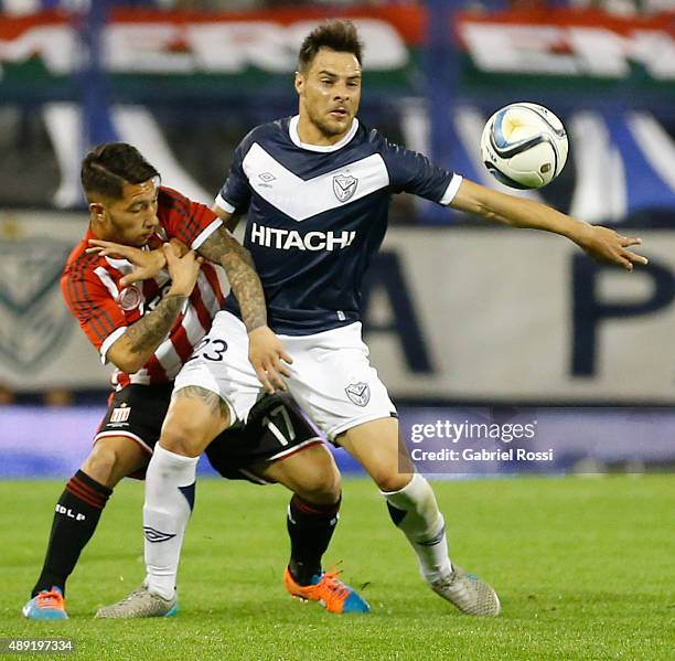 Luciano Acosta of Estudiantes fights for the ball with Leandro Desabato of Velez Sarsfield during a match between Velez Sarsfield and Estudiantes as...