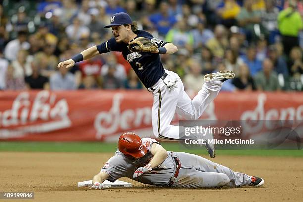 Scooter Gennett of the Milwaukee Brewers jumps over Brennan Boesch of the Cincinnati Reds while attempting a double play during the fifth inning at...