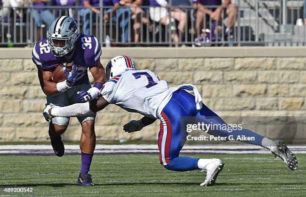 Running back Justin Silmon of the Kansas State Wildcats rushes against safety Xavier Woods of the Louisiana Tech Bulldogs during the second half on...