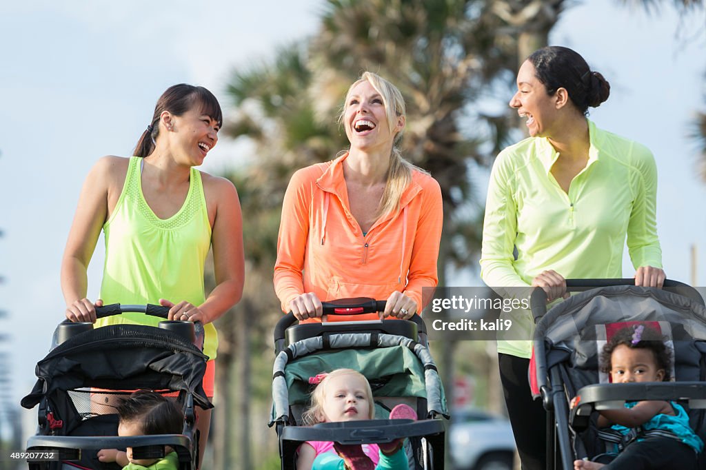 Multi-racial mothers with babies in jogging strollers