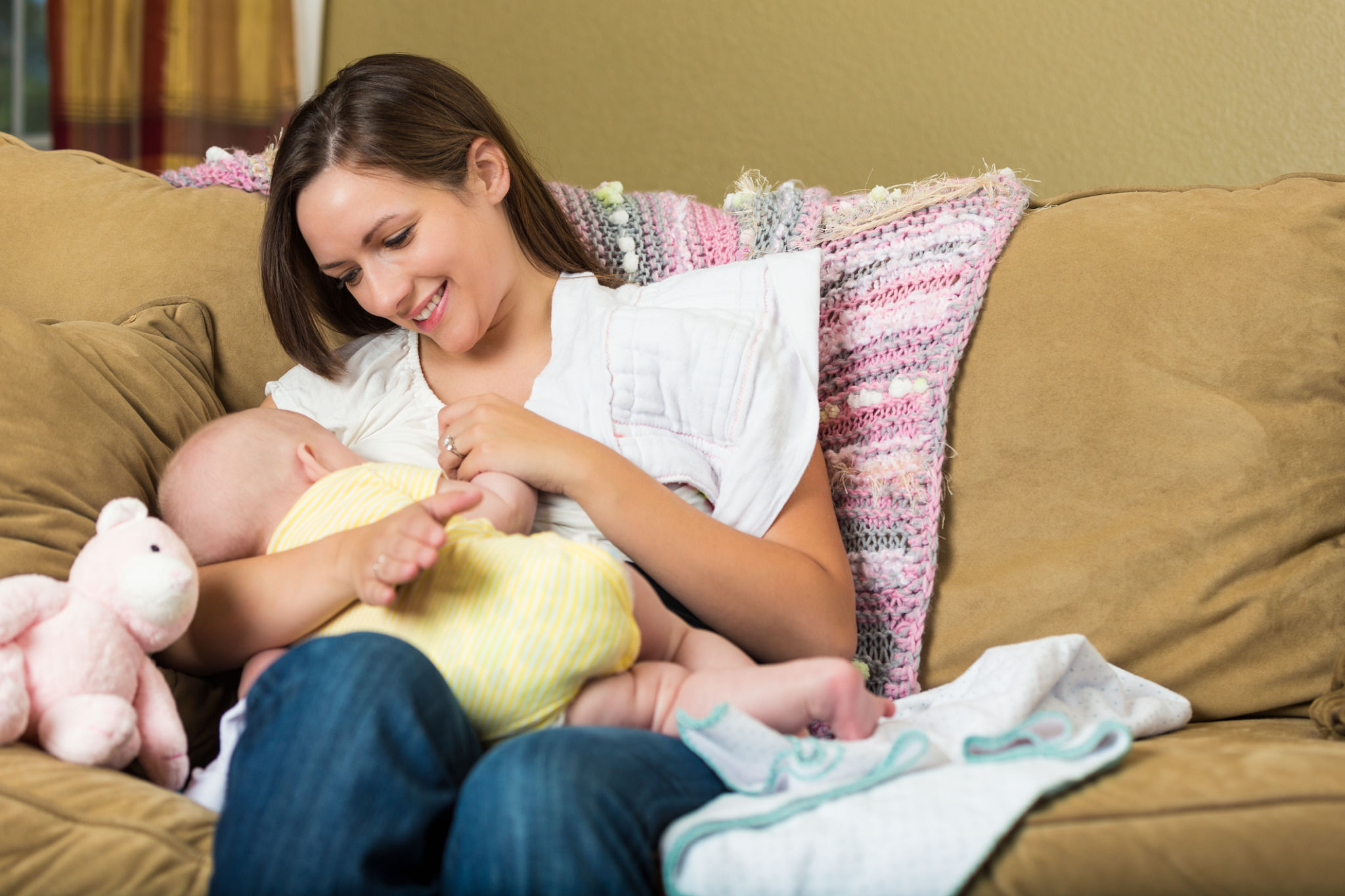 Young mother breastfeeding her baby daughter at home Young mother breastfeeding her baby daughter at home