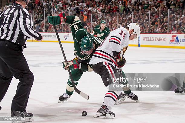 Mikko Koivu of the Minnesota Wild takes a face-off against Jonathan Toews of the Chicago Blackhawks during Game Three of the Second Round of the 2014...