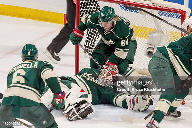 Mikael Granlund helps his Minnesota Wild teammate goalie Ilya Bryzgalov defend their goal against the Chicago Blackhawks during Game Three of the...