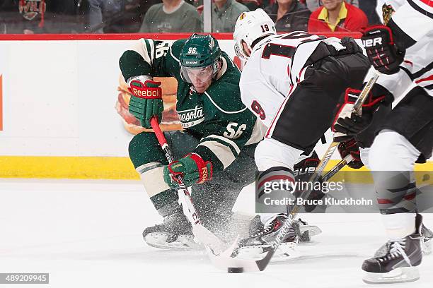 Erik Haula of the Minnesota Wild and Jonathan Toews of the Chicago Blackhawks battle for the puck during Game Three of the Second Round of the 2014...