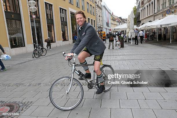 Mike Kraus arrives with his bycicle during the 'Fruehstueck bei Tiffany' at Tiffany Store ahead of the Oktoberfest 2015 on September 19, 2015 in...