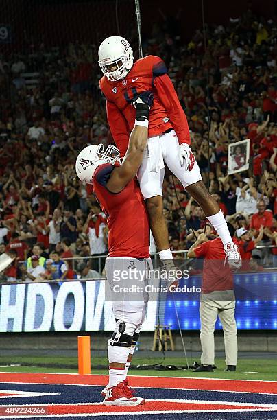Wide receiver David Richards of the Arizona Wildcats celebrates his second quarter touchdown with offensive lineman Freddie Tagaloa during the...