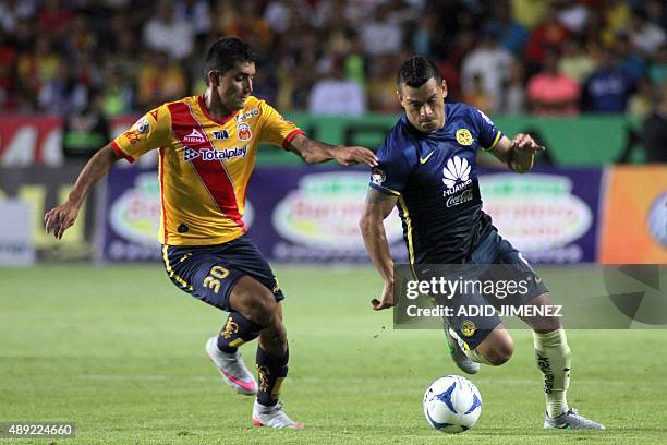 Ignacio Gonzalez of Morelia vies for the ball with Miguel Samudio of America during their Mexican Apertura 2015 tournament football match at the Jose...