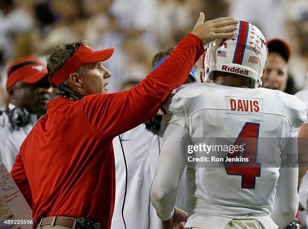 Head coach Chad Morris of the Southern Methodist Mustangs welcomes Matt Davis back to the bench after Davis scored a touchdown against the TCU Horned...