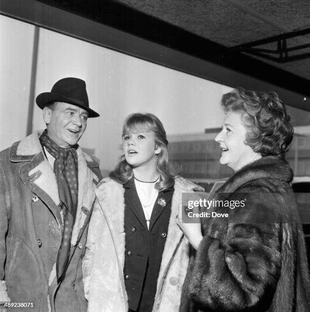 Actor John Mills with his wife Mary Hayley Bell and daughter, fellow actor Hayley Mills, arriving at London Airport, February 8th 1964.