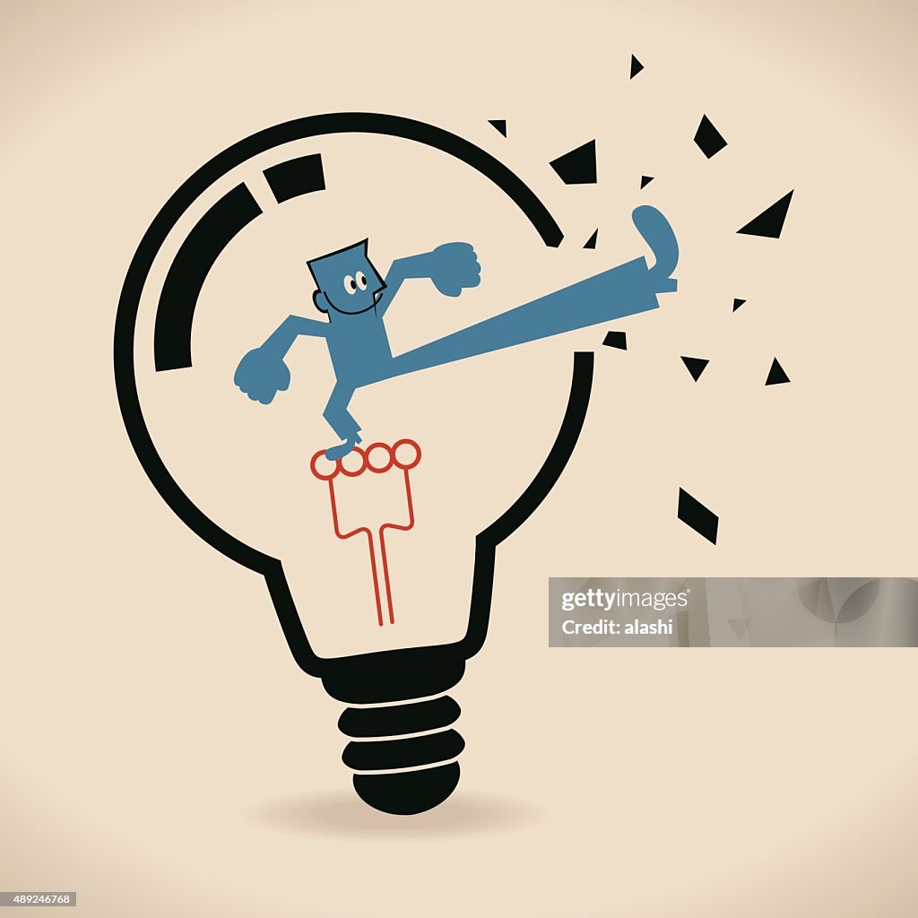 Businessman inside light bulb, breaking it to get out