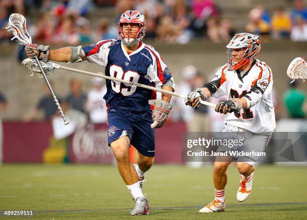 Paul Rabil of the Boston Cannons runs downfield with the ball in the first half past Dillon Roy of the Denver Outlaws at Harvard Stadium on May 10,...