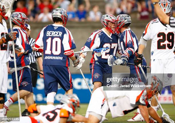 Kevin Buchanan of the Boston Cannons celebrates a goal in the first half with teammates against the Denver Outlaws at Harvard Stadium on May 10, 2014...