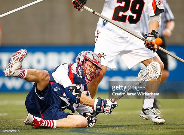 Brent Adams of the Boston Cannons falls while taking a shot in the first half against the Denver Outlaws at Harvard Stadium on May 10, 2014 in...