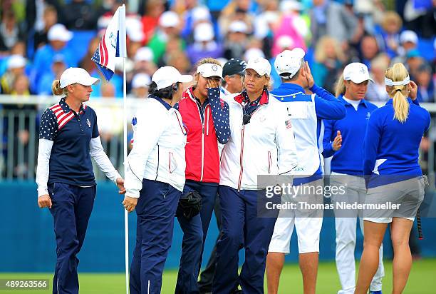 Alison Lee of the United States is comforted by Nancy Lopez and Wendy Ward United States assistant captains on the 18th green after Lee's error in...