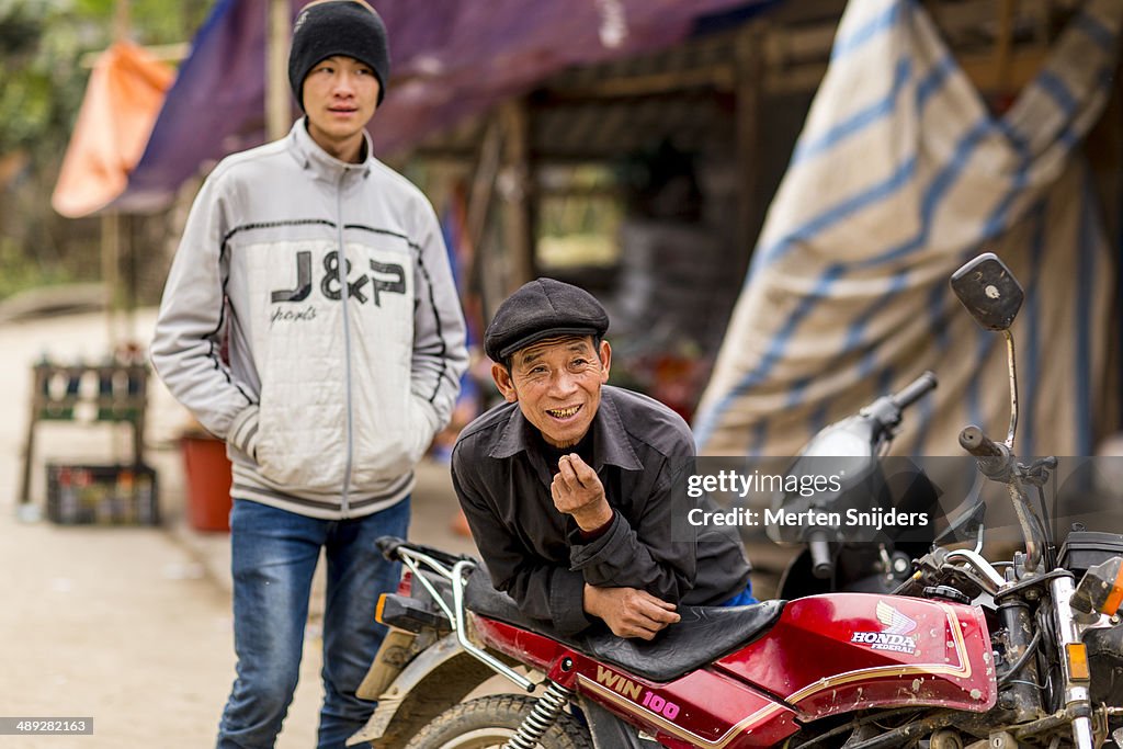 Man leaning on motorcycle smiling