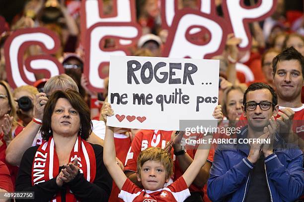 Boy holds a sign reading 'Roger, don't leave me' during the Davis Cup World Group playoff tennis tie match between Switzerland's Roger Federer and...