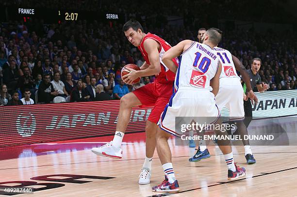 France's shooting guard Evan Fournier defends against Serbia's power forward Zoran Erceg during the third place basketball match between France and...