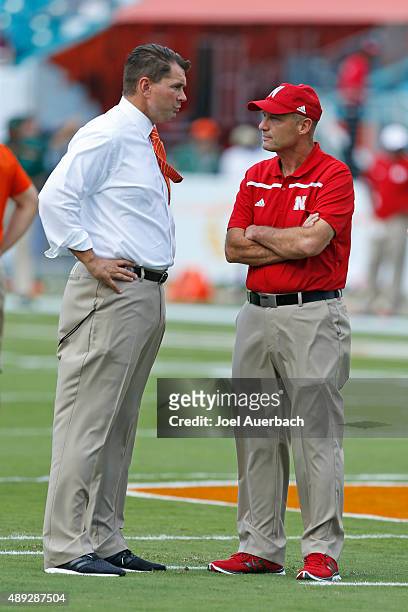 Head coach Al Golden of the Miami Hurricanes and Head coach Mike Riley of the Nebraska Cornhuskers talk as the teams warm up prior to the game on...