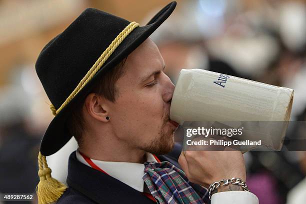 Man in traditional bavarian clothing enjoys beer at the traditional tent after the Parade of Costumes and Riflemen on the second day of the 2015...