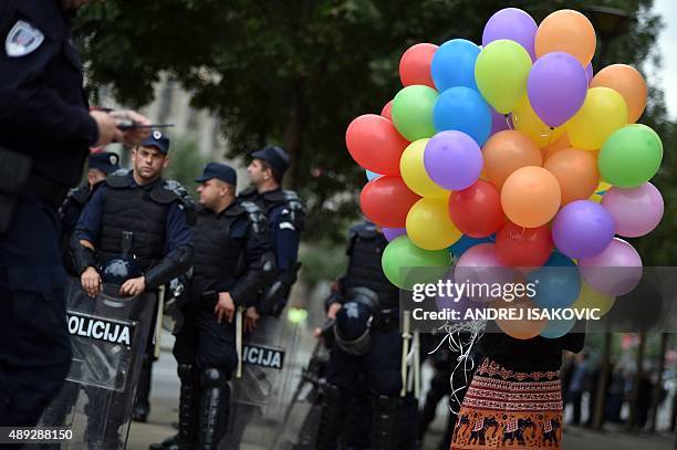 Participant of the Belgrade Gay Pride parade carries balloons in front of a police squad on September 20, 2015. The participants of Belgrade Gay...