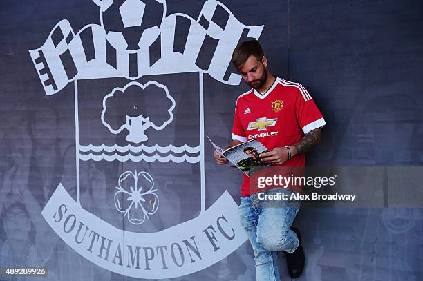 Manchester United fan reads the matchday programme ahead of the Barclays Premier League match between Southampton and Manchester United at St Mary's...