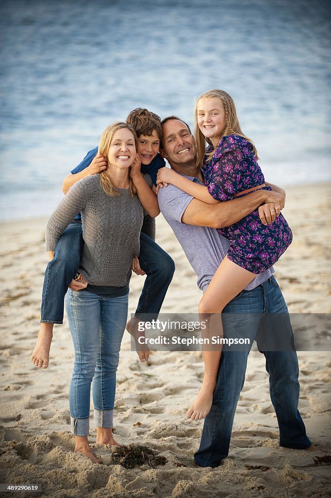 Family of four having fun on the beach