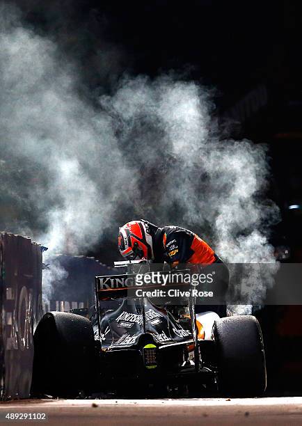 Nico Hulkenberg of Germany and Force India climbs out of his car after crashing during the Formula One Grand Prix of Singapore at Marina Bay Street...