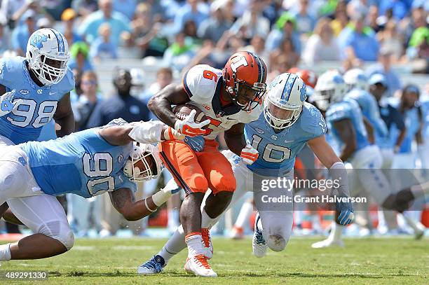 Nazair Jones and Jeff Schoettmer of the North Carolina Tar Heels tackle Josh Ferguson of the Illinois Fighting Illini during their game at Kenan...