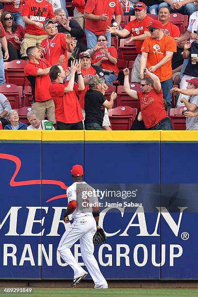 Right fielder Roger Bernadina of the Cincinnati Reds watches as a lead off home run off the bat of Charlie Blackmon of the Colorado Rockies sails...