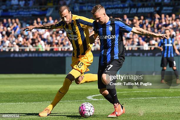 Evangelos Moras of Hellas Verona and Jasmin Kurtic of Atalanta compete for the ball during the Serie A match between Atalanta BC and Hellas Verona FC...