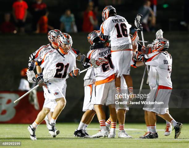 Chris Bocklet of the Denver Outlaws is mobbed by teammates after scoring the game-winning goal in overtime against the Boston Cannons at Harvard...