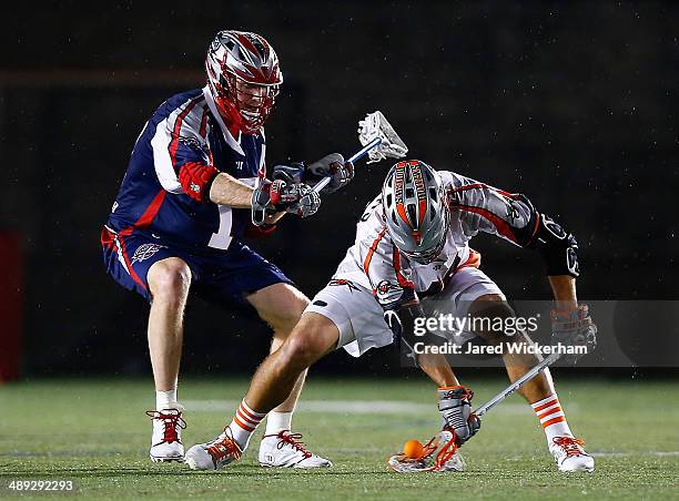 Brodie Merrill of the Boston Cannons and Jeremy Sieverts of the Denver Outlaws fight for the ball in the second half at Harvard Stadium on May 10,...