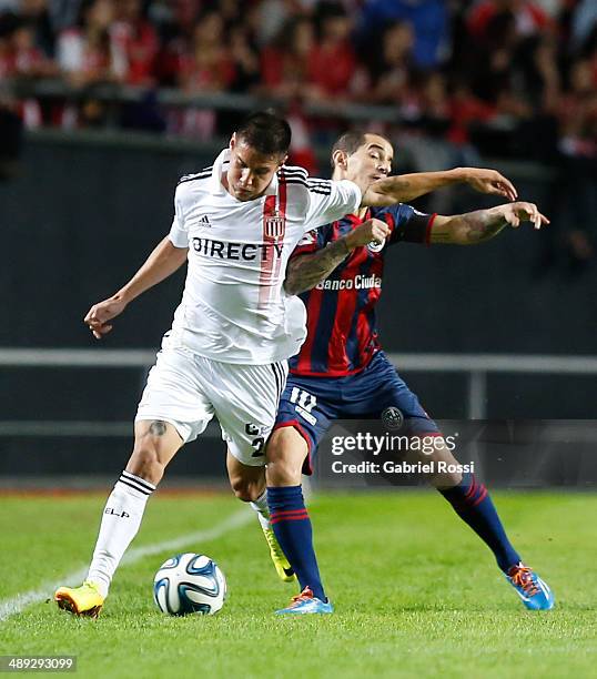 Carlos Auzqui of Estudiantes fights for the ball with Leandro Romagnoli of San Lorenzo during a match between Estudiantes and San Lorenzo as part of...