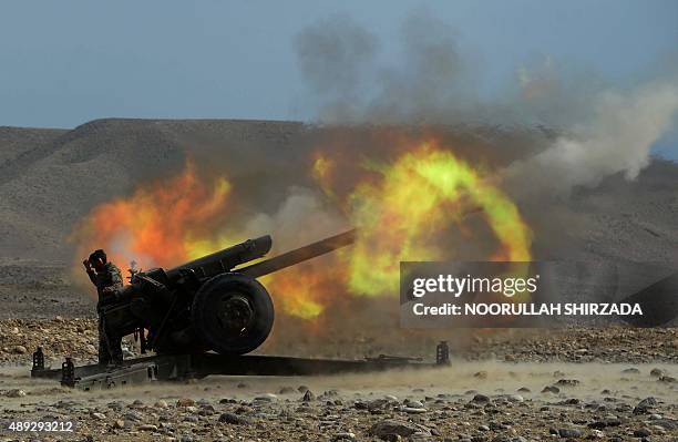 An Afghan National Army soldier fires an artillery shell during ongoing clashes between Afghan security forces and militants in Kot district of...