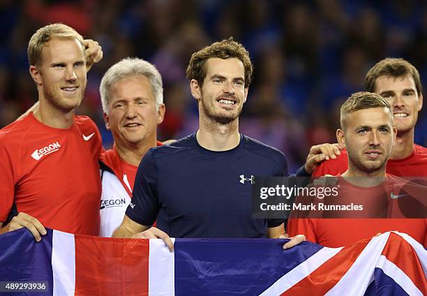 Andy Murray of Great Britain celebrates winning his singles match against Bernard Tomic of Australia with his fellow GB team mates, taking Great...