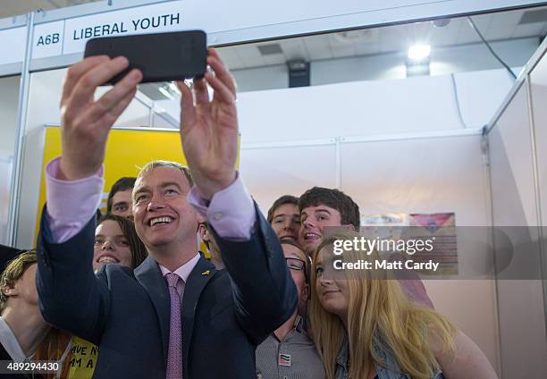 Leader of the Liberal Democrats Tim Farron takes a selfie photograph with young Liberals as he visits the trade and exhibition stands on the second...