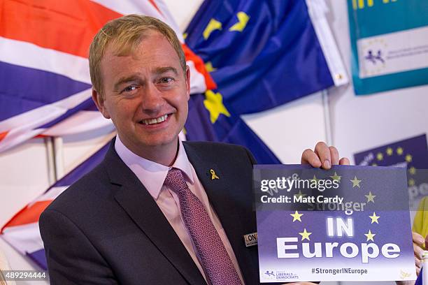 Leader of the Liberal Democrats Tim Farron holds up a pro-European poster as he visits the trade and exhibition stands on the second day of the...