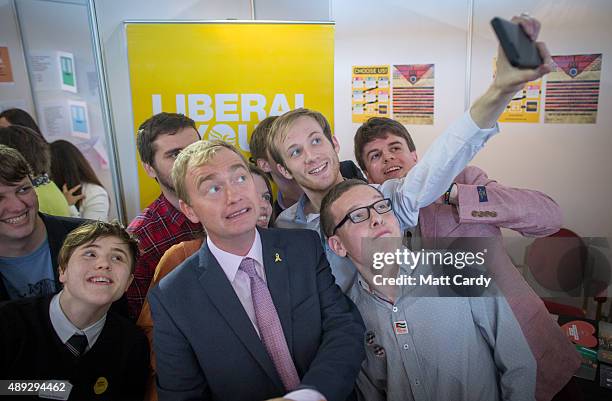 Leader of the Liberal Democrats Tim Farron takes a selfie photograph with young Liberals as he visits the trade and exhibition stands on the second...