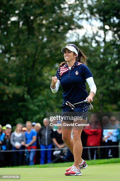 Gerina Piller of the United States holes a par putt on the 18th green to win her match by 1 hole against Caroline Masson of the European team during...