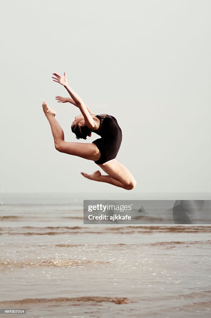 Female gymnast exercising at the seaside