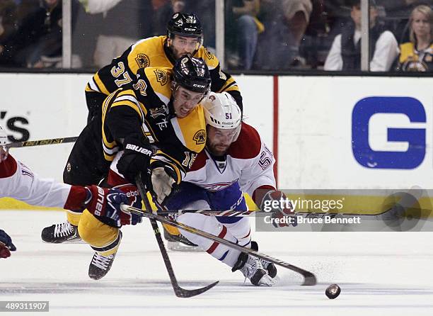 Reilly Smith of the Boston Bruins and David Desharnais of the Montreal Canadiens battle for the puck during the second period during Game Five of the...