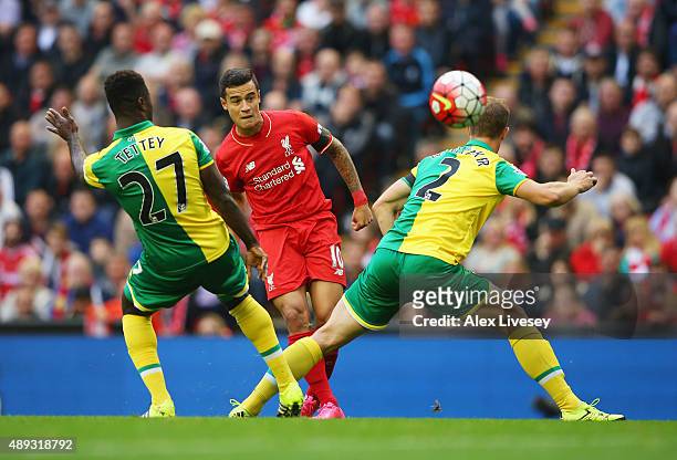 Philippe Coutinho of Liverpool shoots past Alexander Tettey and Steven Whittaker of Norwich City during the Barclays Premier League match between...