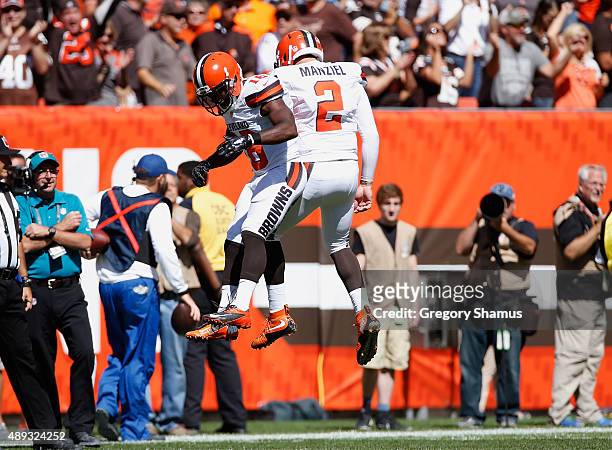 Johnny Manziel of the Cleveland Browns celebrates a first quarter touchdown pass with Andrew Hawkins while playing the Tennessee Titans at...