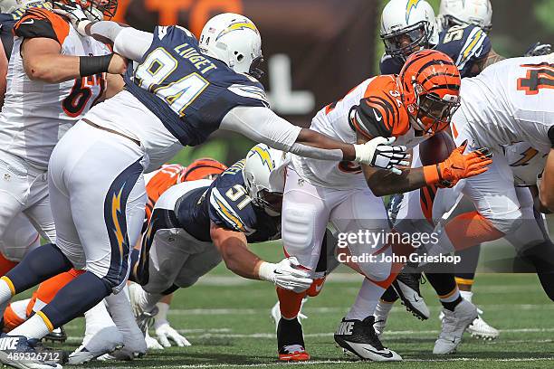 Corey Liuget of the San Diego Chargers and Kyle Emanuel of the San Diego Chargers combine to tackle Jeremy Hill of the Cincinnati Bengals during the...