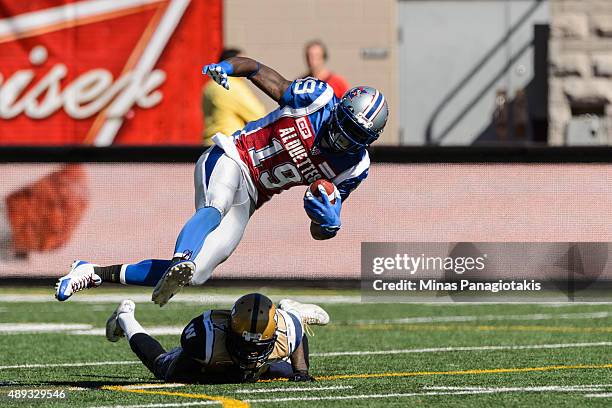 Green of the Montreal Alouettes jumps over Demond Washington of the Winnipeg Blue Bombers during the CFL game at Percival Molson Stadium on September...