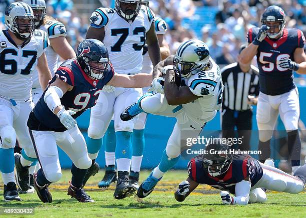 Jared Crick of the Houston Texans tackles Jonathan Stewart of the Carolina Panthers during their game at Bank of America Stadium on September 20,...