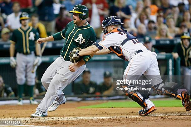 Billy Butler of the Oakland Athletics is tagged out by Max Stassi of the Houston Astros trying to score in the second inning at Minute Maid Park on...