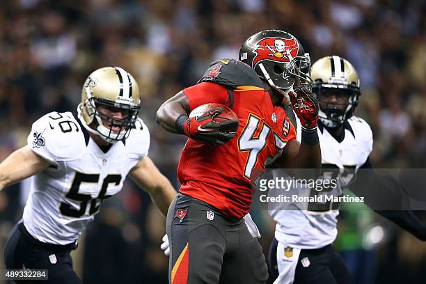 Bobby Rainey of the Tampa Bay Buccaneers is pursued by Michael Mauti and Damian Swann of the New Orleans Saints during the third quarter of a game at...