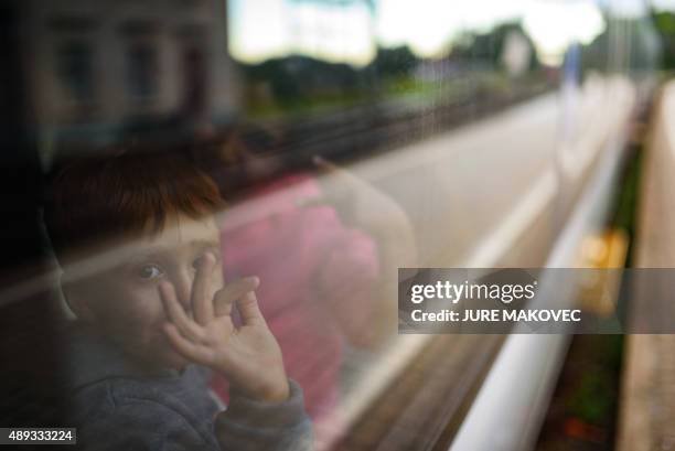 Children react after boarding a train to Graz at a railway station in Spielfeld on September 20, 2015. Some 150 migrants entered Austria from across...